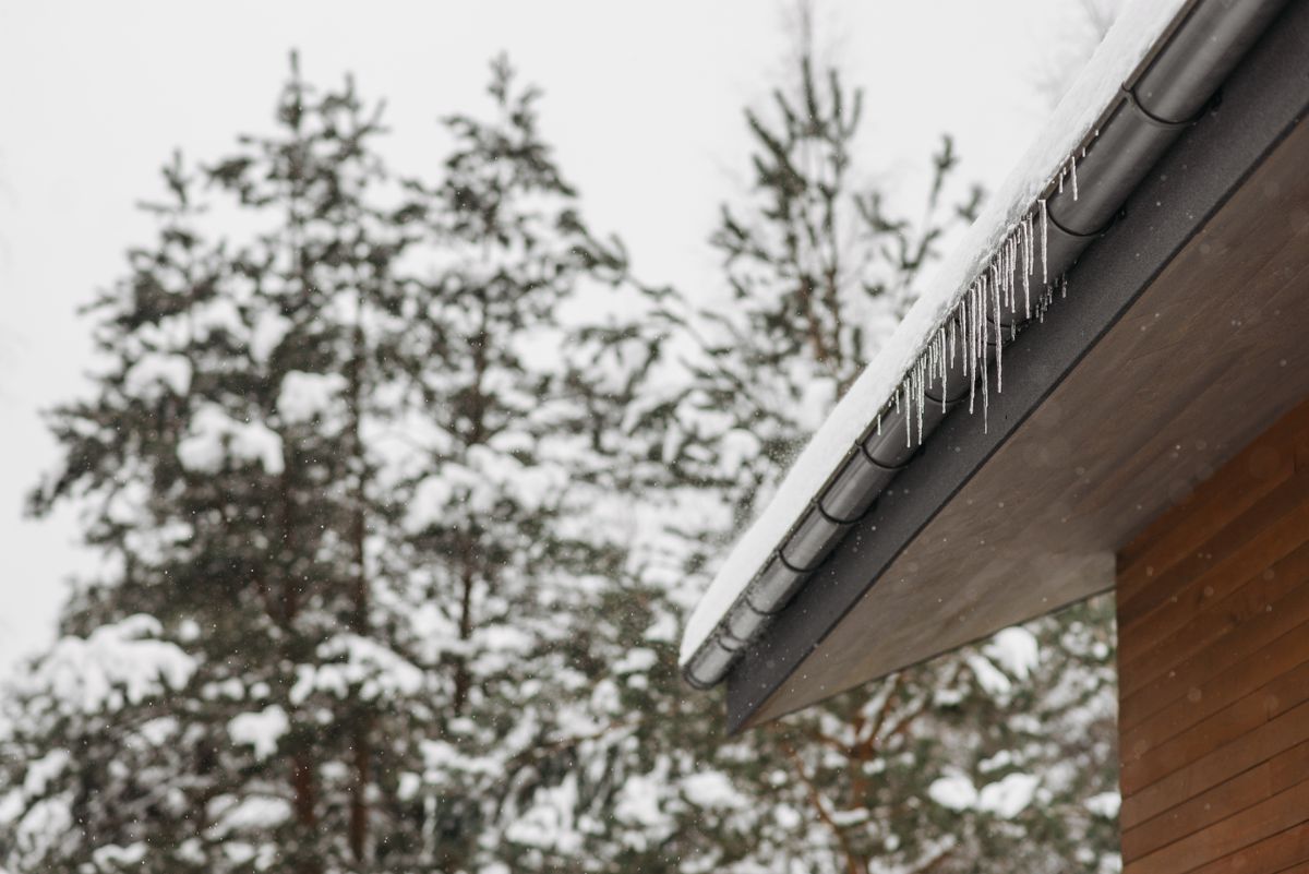 Icicles hanging from a snow-covered roof edge and gutter